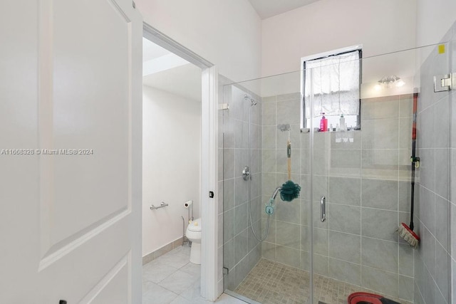 bathroom with tile patterned flooring, toilet, and a shower with door