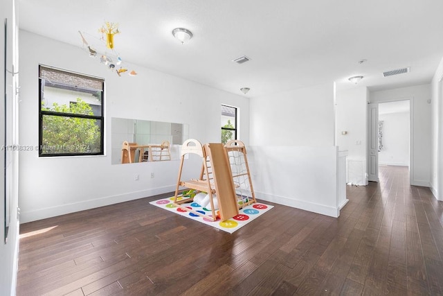 game room with dark wood-type flooring and plenty of natural light