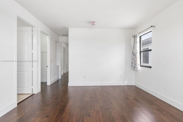 spare room featuring dark wood-type flooring