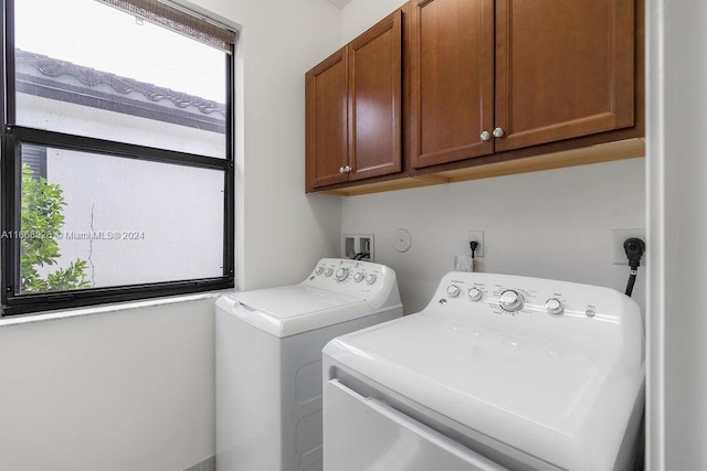 washroom with washer and clothes dryer and cabinets