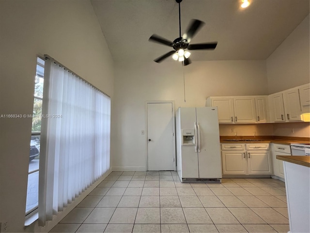 kitchen featuring ceiling fan, light tile patterned floors, high vaulted ceiling, white cabinetry, and white refrigerator with ice dispenser