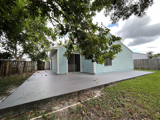 rear view of property with a yard and a patio