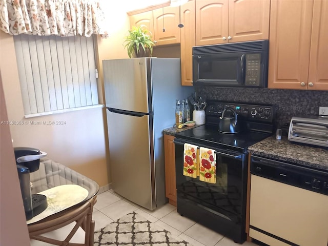 kitchen featuring dark stone countertops, black appliances, light tile patterned flooring, and backsplash