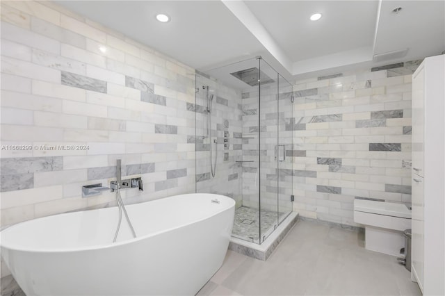 bathroom featuring plus walk in shower and tile walls