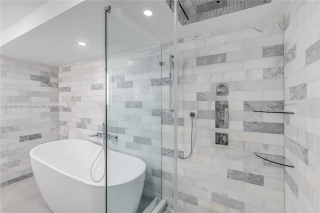 bathroom with shower with separate bathtub and tile walls