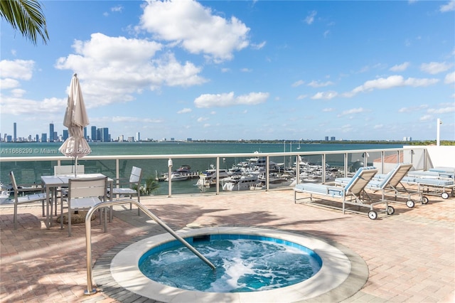 view of swimming pool featuring a community hot tub and a water view