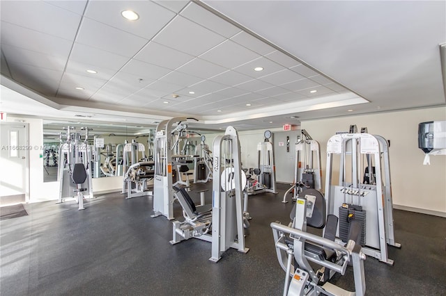 exercise room featuring a drop ceiling and a raised ceiling