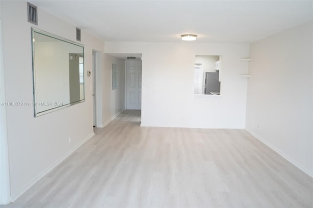 empty room with light wood-type flooring and a wealth of natural light