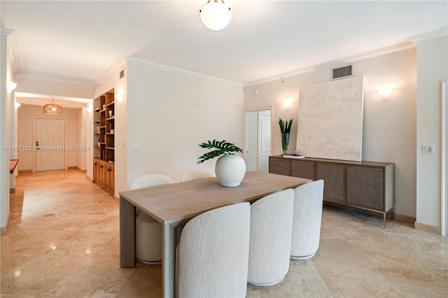 dining room with built in shelves, a textured ceiling, and crown molding