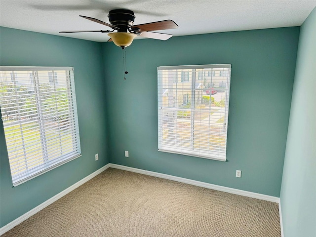 empty room featuring ceiling fan, carpet floors, and a textured ceiling