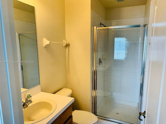 bathroom with vanity, toilet, and an enclosed shower