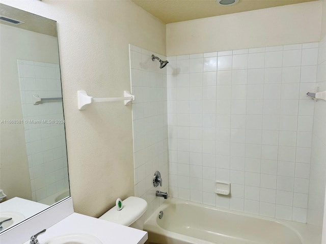 full bathroom featuring tiled shower / bath combo, vanity, and toilet