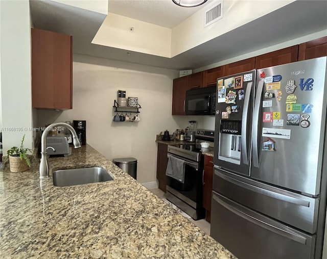 7275 SW 90th Way Unit 407, Miami, FL 33156 - kitchen featuring visible vents, a sink, reddish brown cabinets, stainless steel appliances, and light stone counters