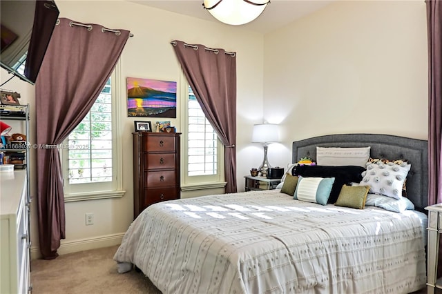 bedroom with light colored carpet and baseboards