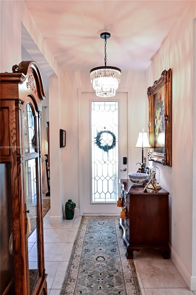 entryway with an inviting chandelier and light tile patterned flooring