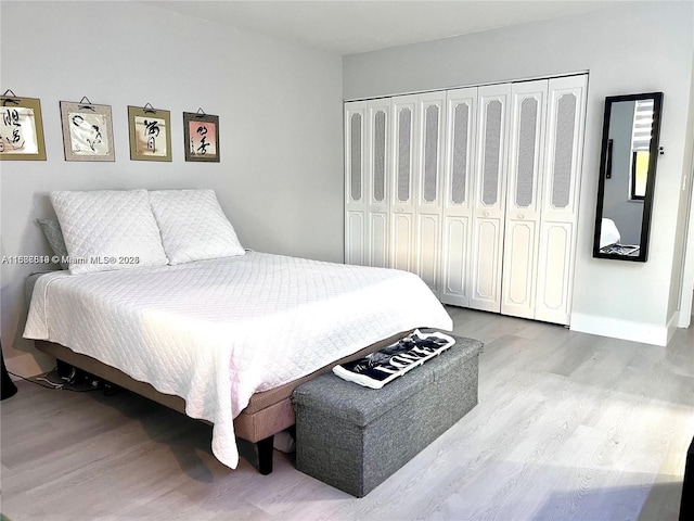 bedroom with light hardwood / wood-style flooring and a closet