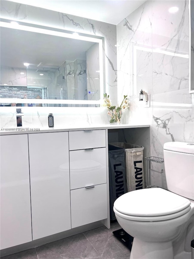 bathroom with a shower with door, vanity, and toilet