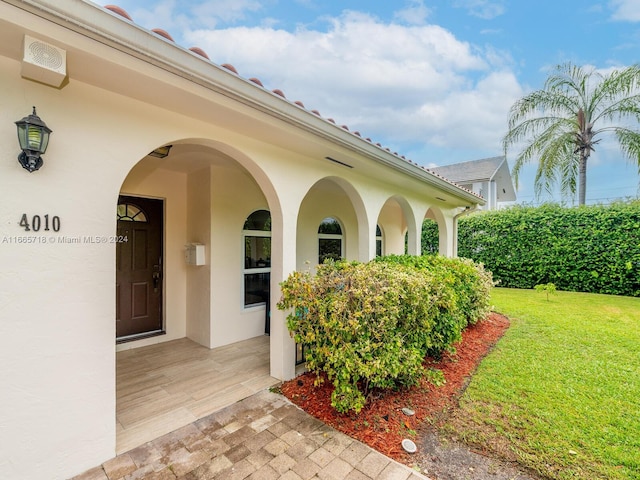 entrance to property with a lawn