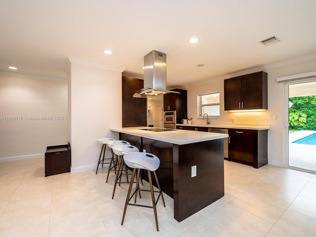 kitchen with appliances with stainless steel finishes, kitchen peninsula, a kitchen bar, crown molding, and island exhaust hood