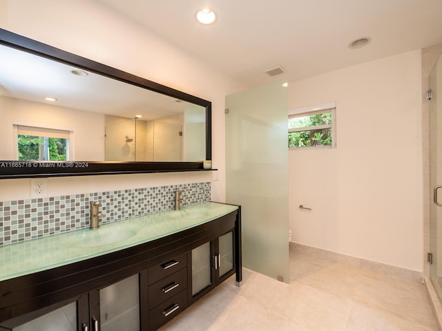 bathroom featuring walk in shower, vanity, tile patterned floors, and tasteful backsplash