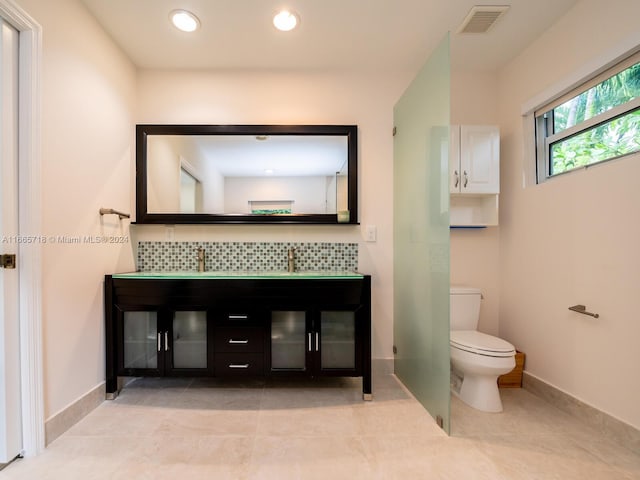 bathroom with tile patterned floors, vanity, toilet, and decorative backsplash