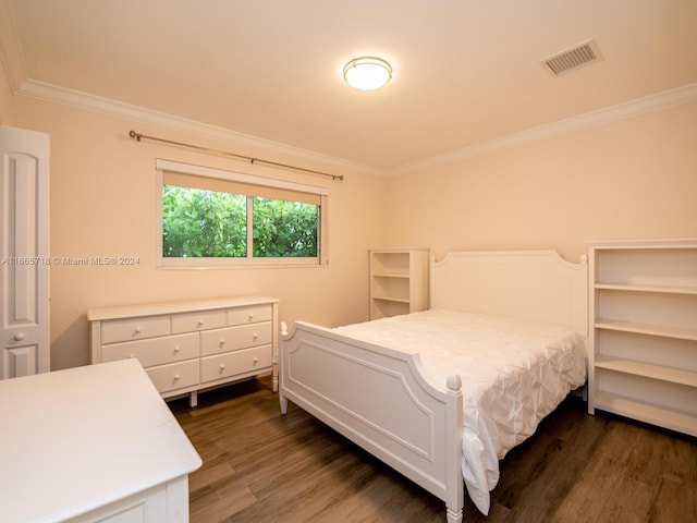 bedroom with ornamental molding and dark hardwood / wood-style floors