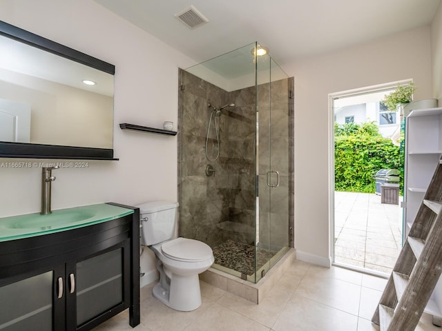 bathroom with vanity, tile patterned floors, toilet, and a shower with shower door