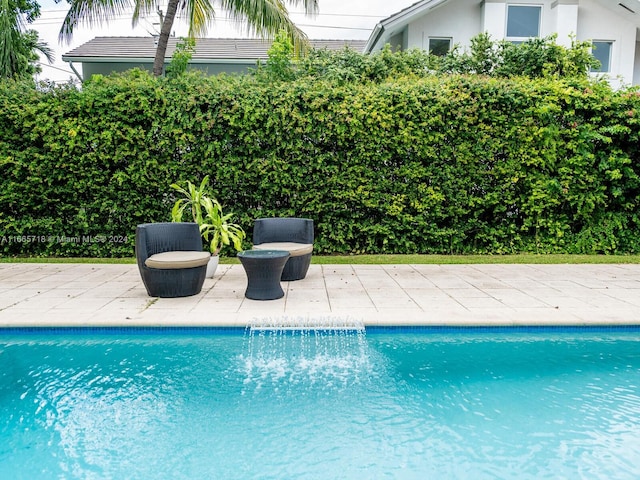 view of pool with pool water feature and a patio area