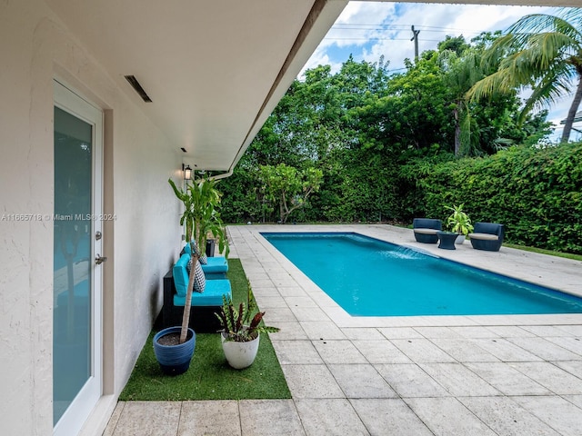 view of pool with a patio area and pool water feature