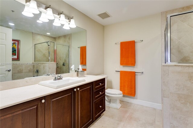 bathroom with vanity, tile patterned flooring, toilet, and an enclosed shower