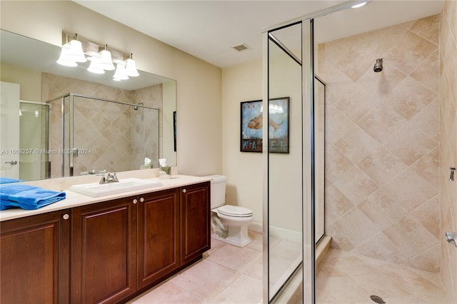 bathroom with vanity, toilet, tile patterned floors, and a shower with door