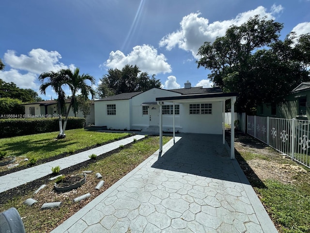 ranch-style home with a front yard and a carport