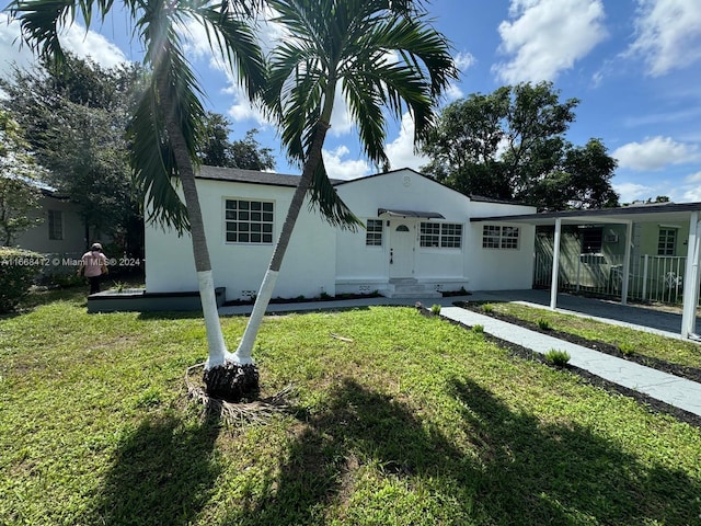 rear view of house featuring a lawn and a carport