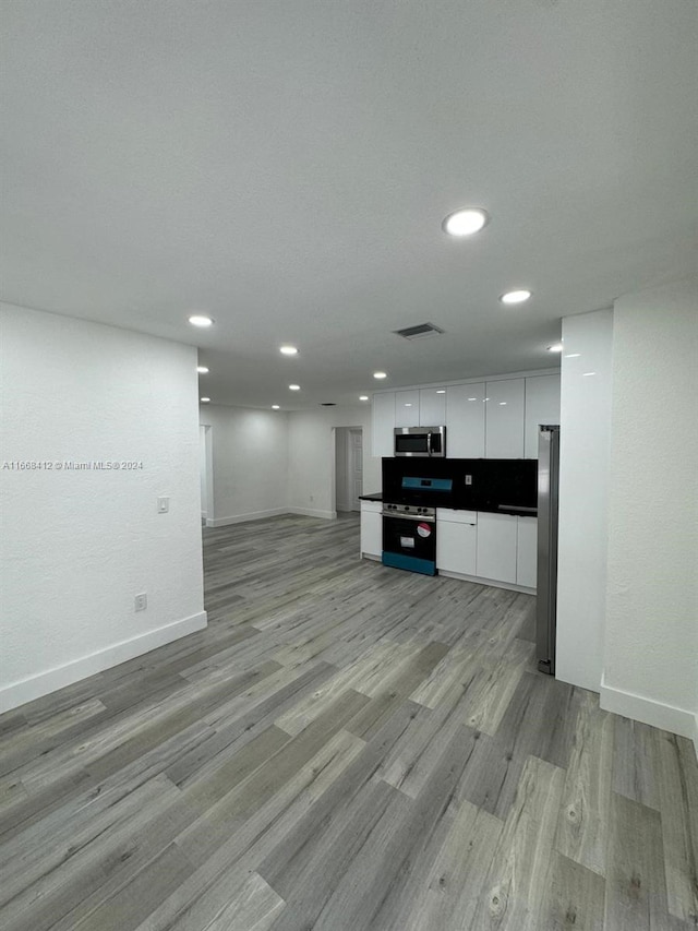 kitchen featuring appliances with stainless steel finishes, light hardwood / wood-style floors, and white cabinetry