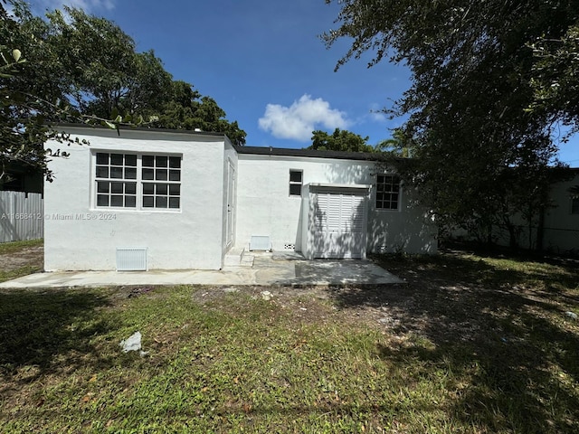 back of property with a lawn and a patio area