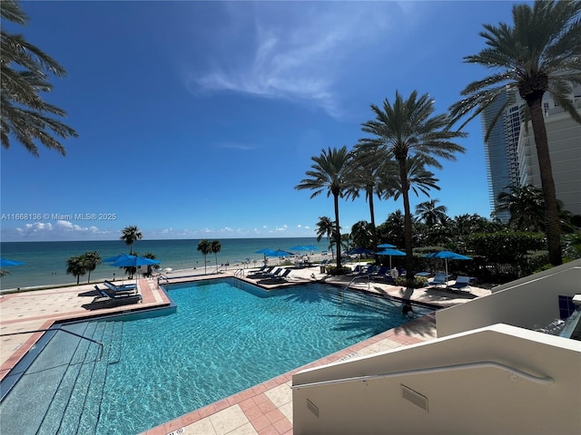 view of pool featuring a patio and a water view