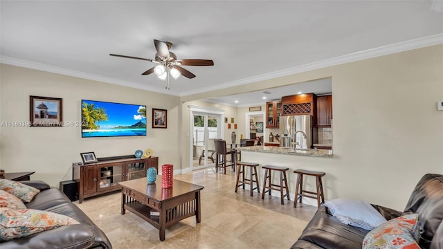 living room with ceiling fan, sink, and ornamental molding