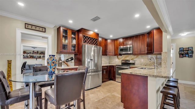 kitchen with decorative backsplash, ornamental molding, sink, and stainless steel appliances