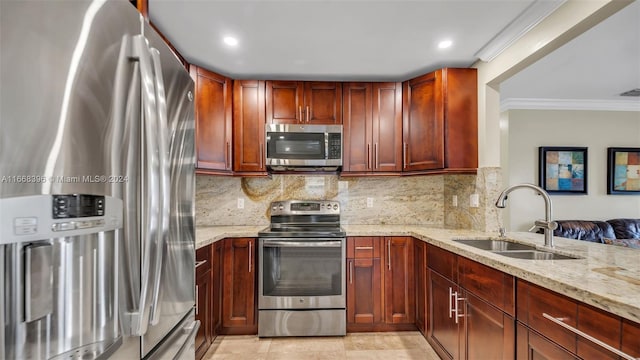 kitchen featuring ornamental molding, stainless steel appliances, light stone countertops, and sink