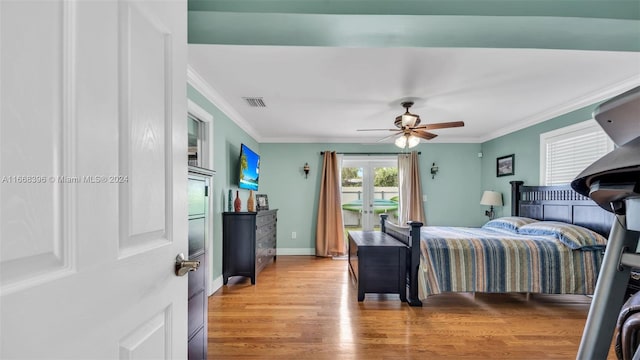 bedroom with light hardwood / wood-style flooring, ceiling fan, and ornamental molding