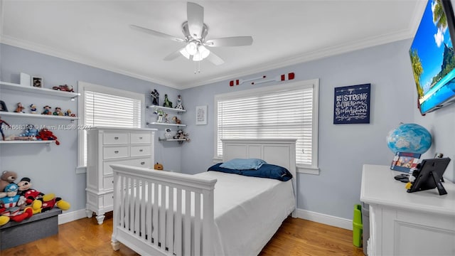 bedroom featuring light wood-type flooring, ornamental molding, and ceiling fan