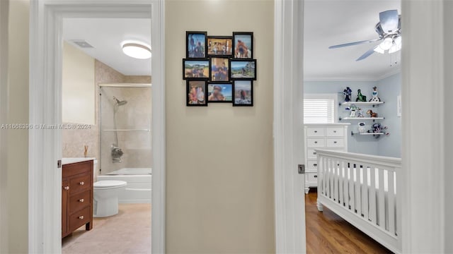 full bathroom with crown molding, bath / shower combo with glass door, ceiling fan, vanity, and toilet