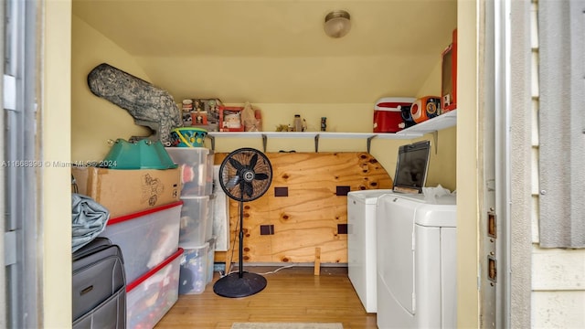 clothes washing area with hardwood / wood-style floors and washing machine and clothes dryer