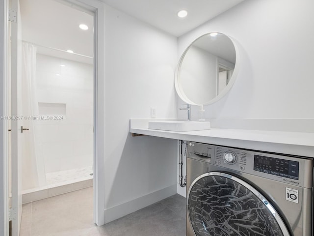 laundry area with tile patterned floors, sink, and washer / dryer