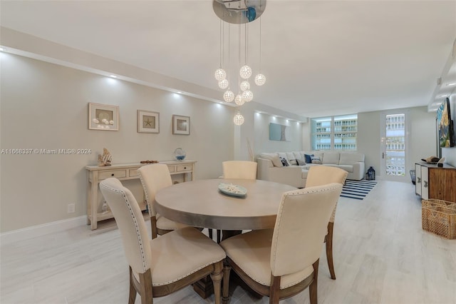 dining room featuring light wood-style flooring and baseboards