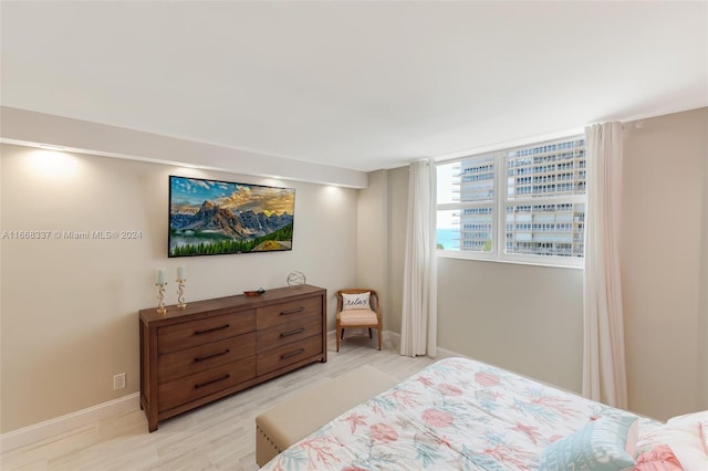 bedroom with light wood-type flooring and baseboards
