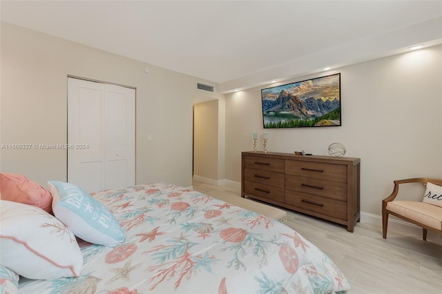 bedroom with light wood-style floors, a closet, baseboards, and visible vents