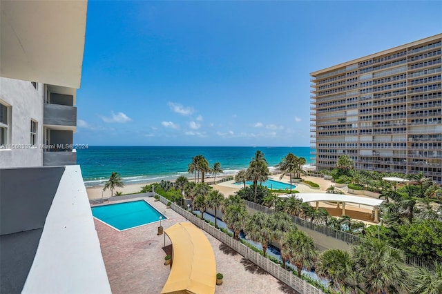 view of swimming pool with a water view and a beach view