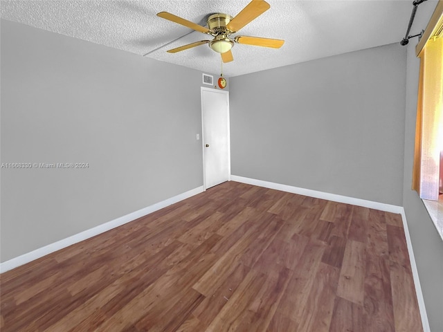 empty room with ceiling fan, a textured ceiling, and wood-type flooring