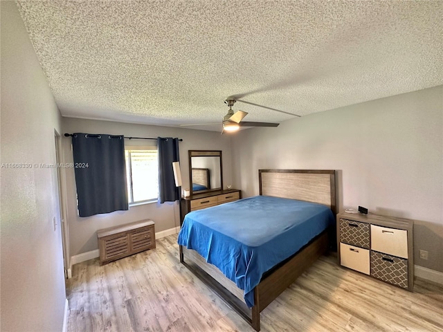 bedroom with a textured ceiling, ceiling fan, and light hardwood / wood-style flooring